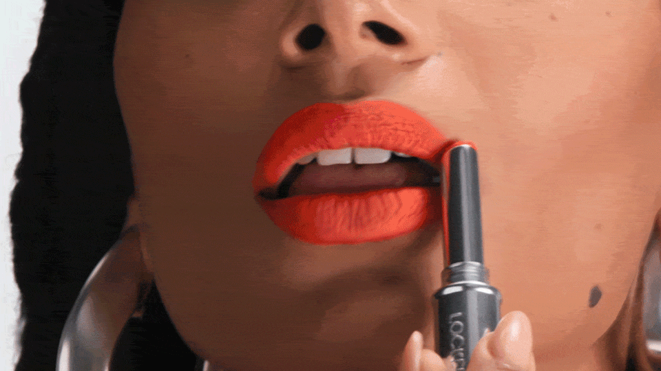 Model applying lipstick for Passion Fruit Oil for Comfort benefits.